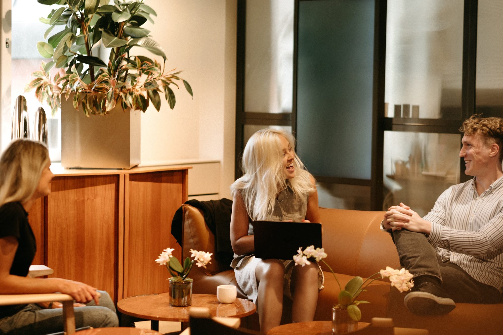Three Creandum team members in conversation on a sofa in the office